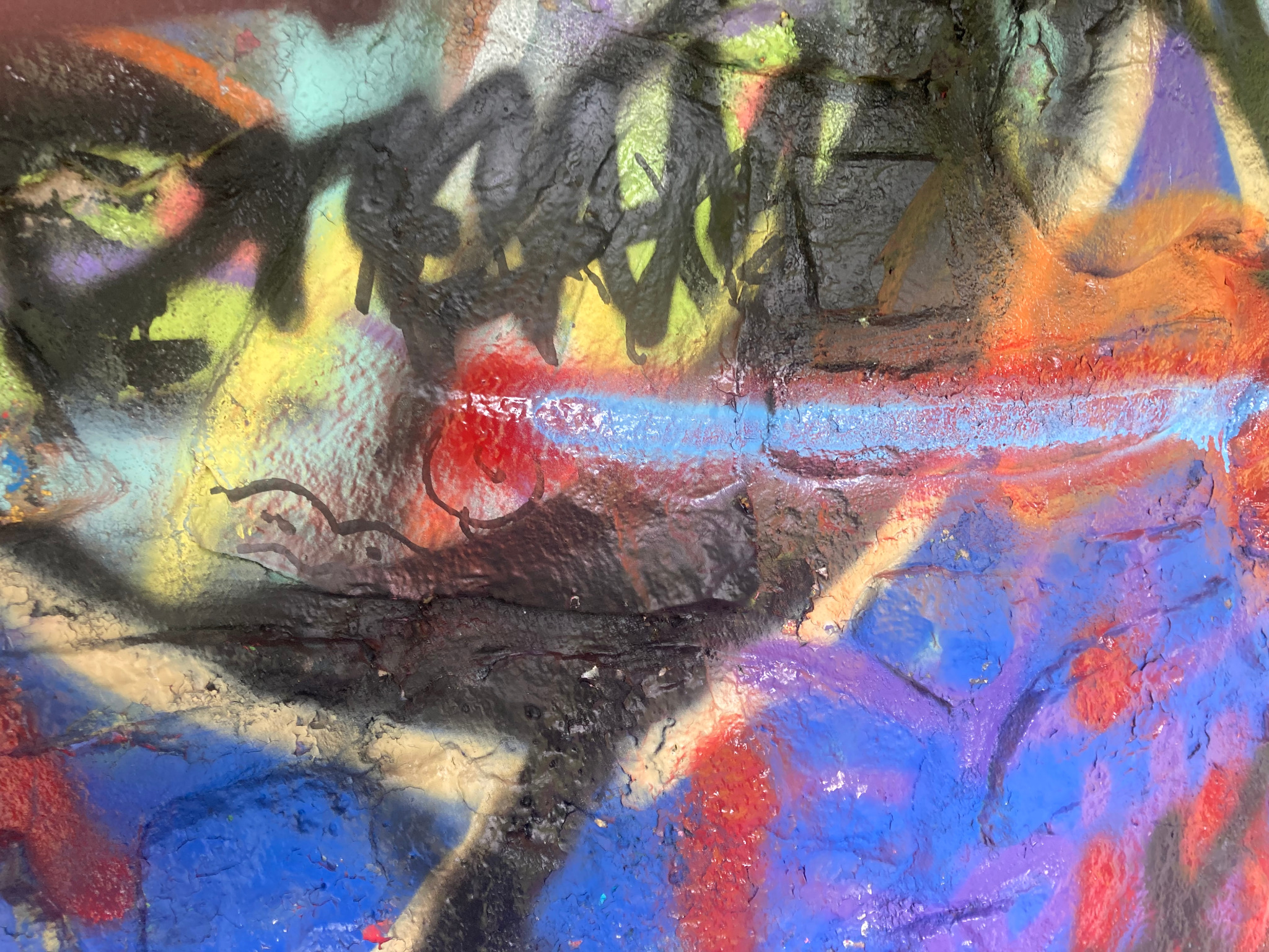 Layered spray paint on textured masonry